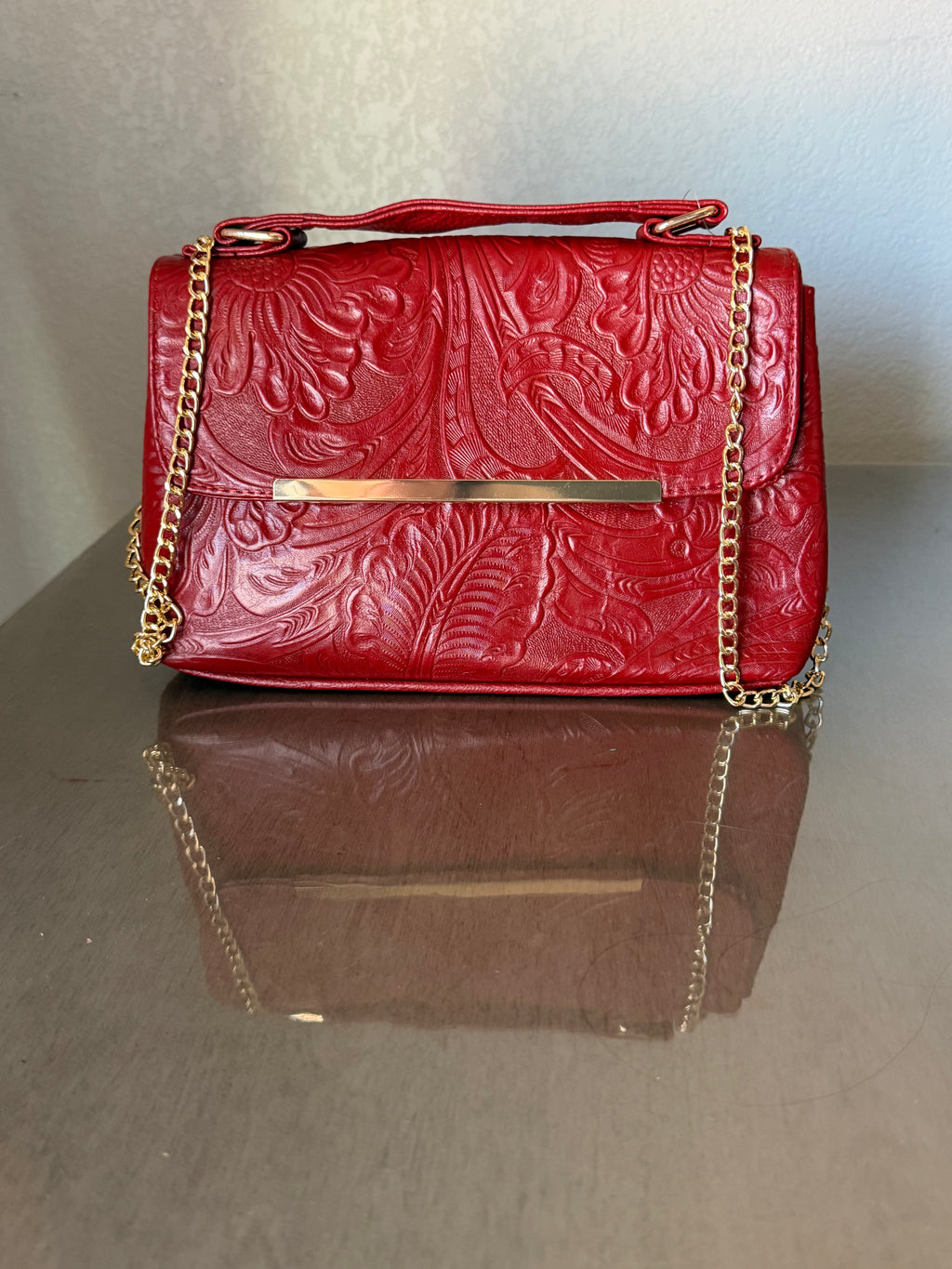 This brown, floral-embossed leather satchel medium gold tooling top handle bag