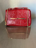 This brown, floral-embossed leather satchel medium gold tooling top handle bag