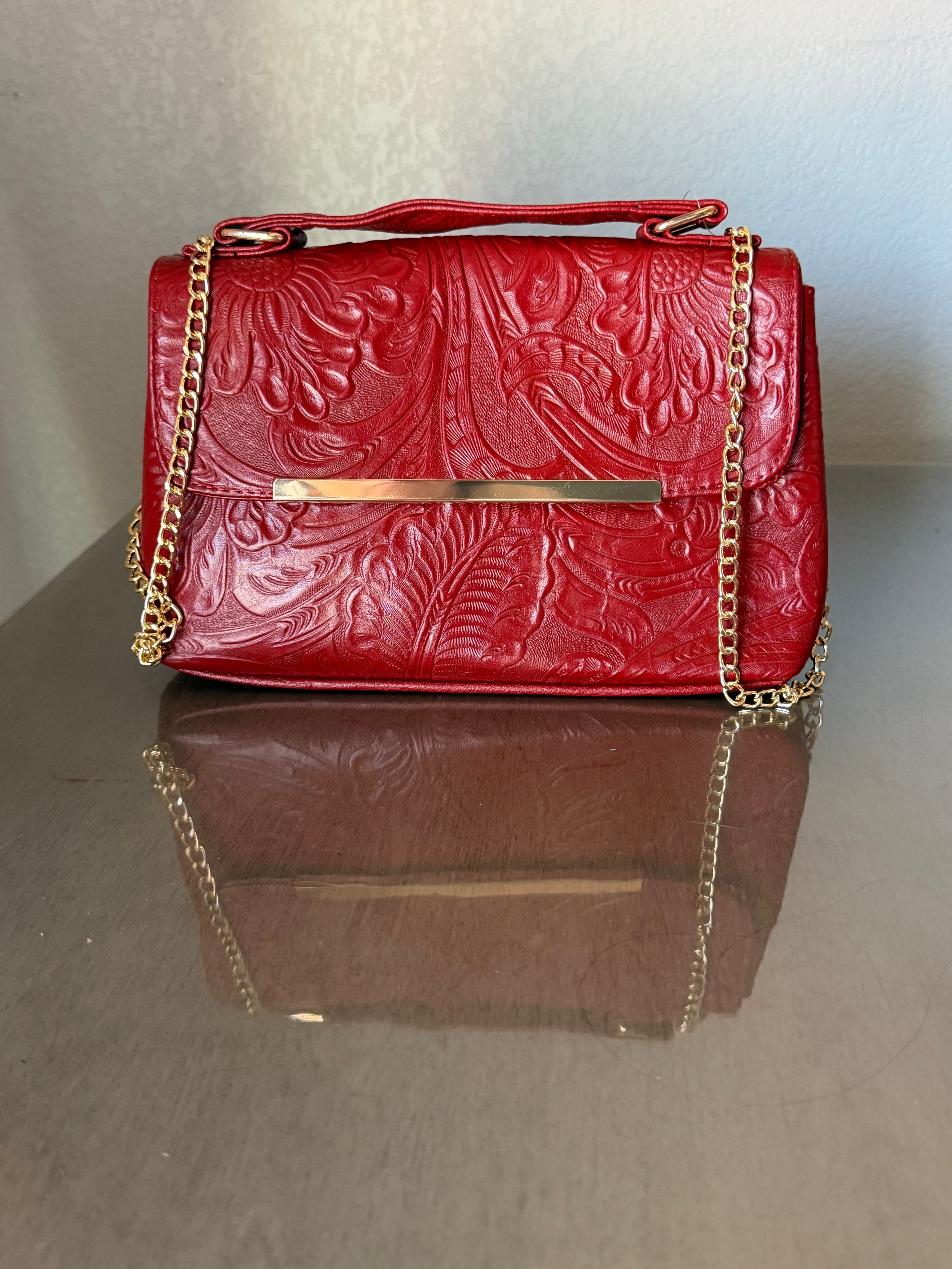 This brown, floral-embossed leather satchel medium gold tooling top handle bag