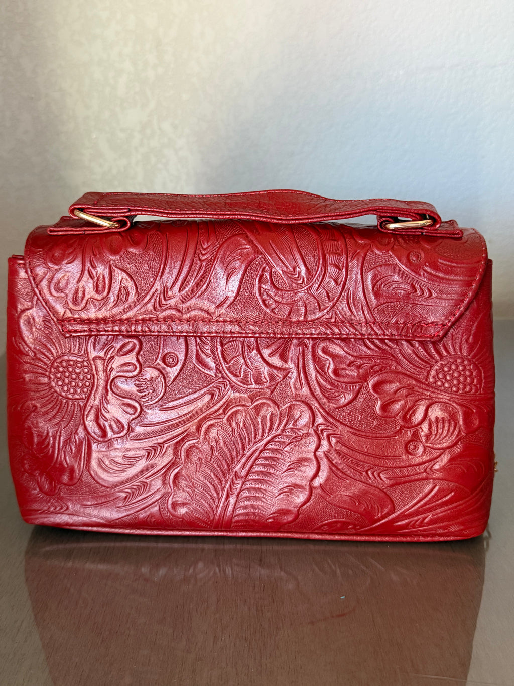 This brown, floral-embossed leather satchel medium gold tooling top handle bag